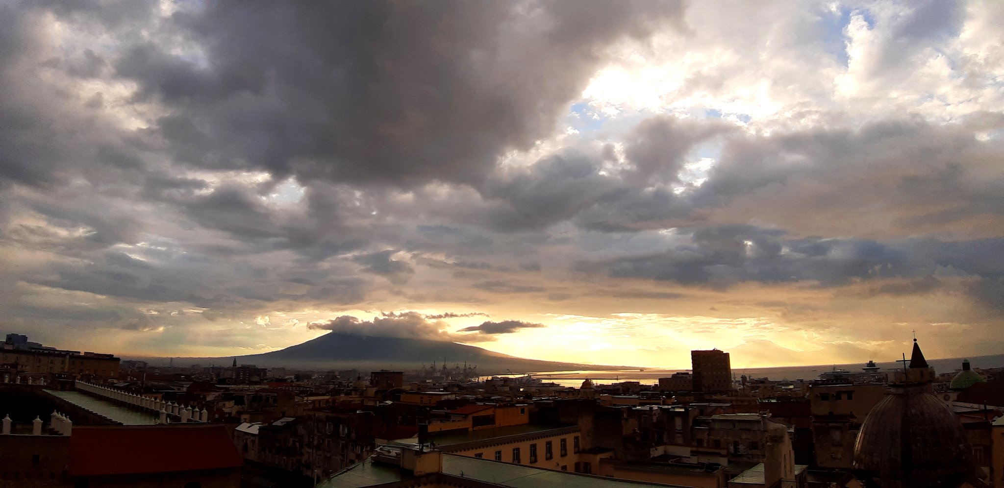 Napoli çatılarının ardında gün batımında Vezüv